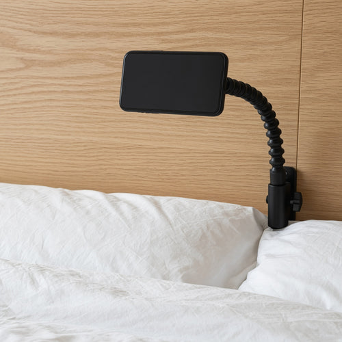 Black gooseneck phone holder clamped to a headboard over a bed